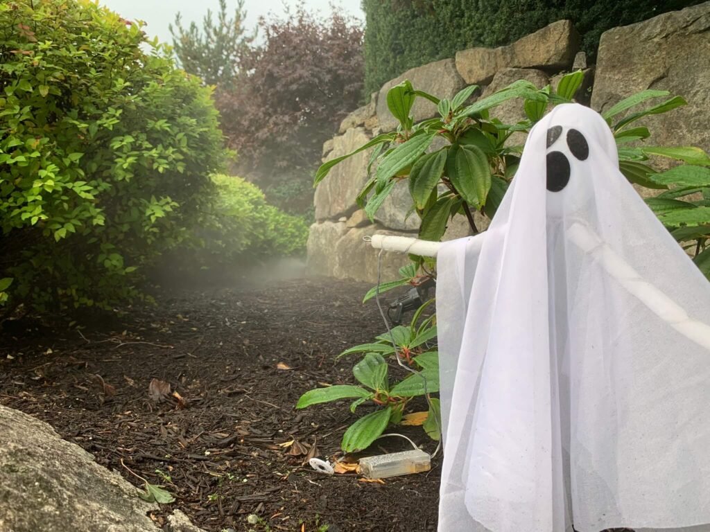 Winterization Blowout: Preparing Your Irrigation for the Cold Season A ghost decoration beside an irrigation system winterization blowout in a garden setting.