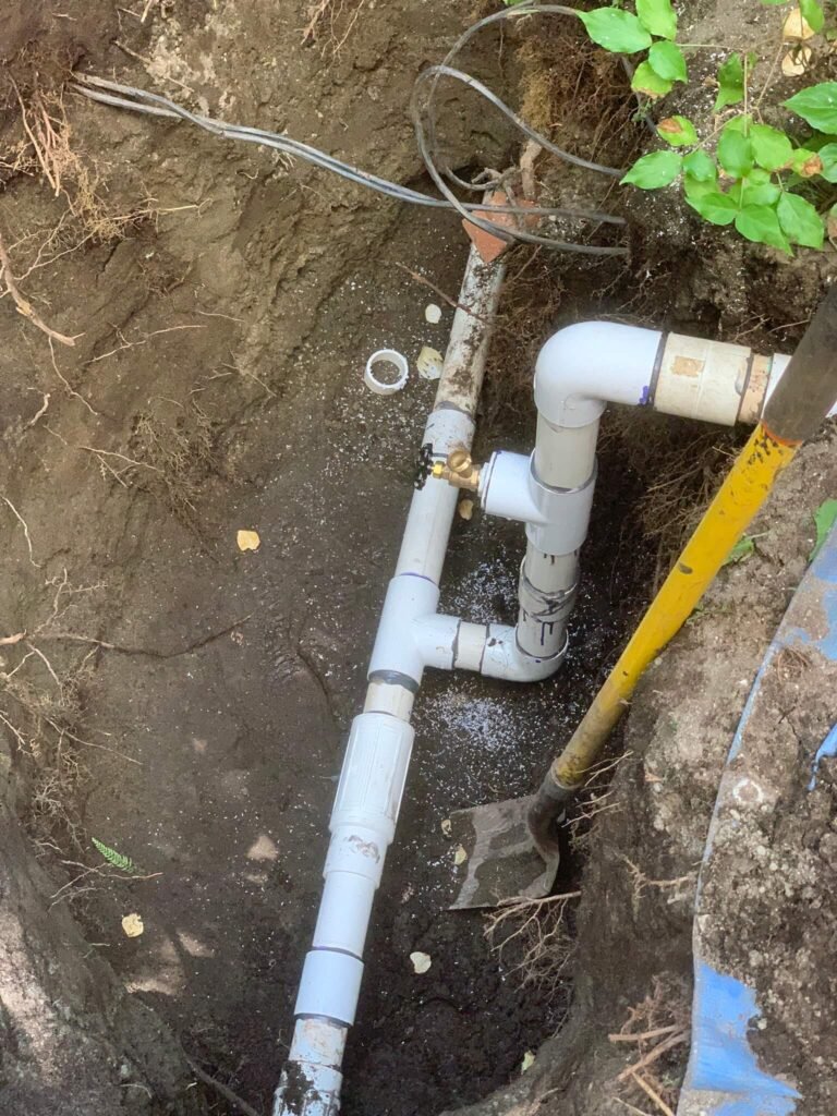 West Vancouver Irrigation Repair: Expert Solutions for Your Irrigation Needs A close-up of an irrigation system repair in progress, showing a skilled technician working on a pipe junction.