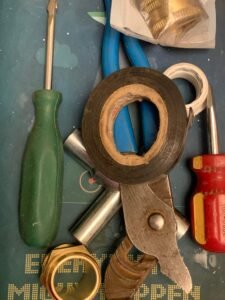 Essential Tools & Parts for Restarting Your Sprinkler System DIY sprinkler system restart tools: screwdrivers, pliers, fittings, tape.