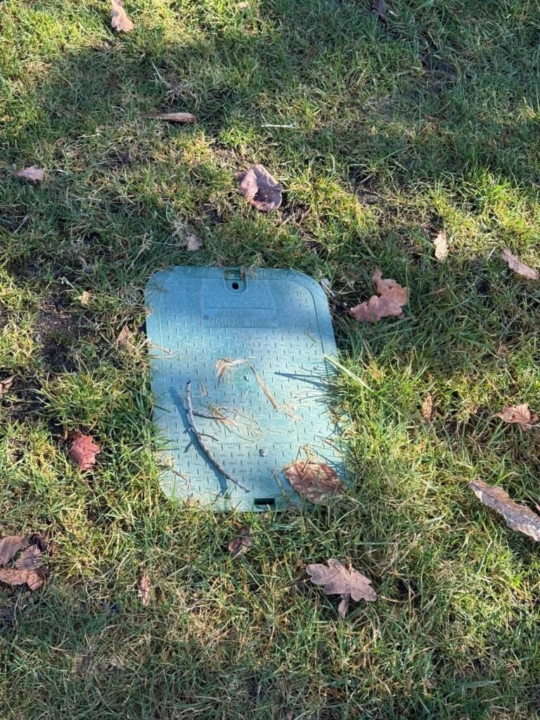 Inspect and Clean Your Sprinkler System's Main Valve Box Green main valve box in a grassy lawn.